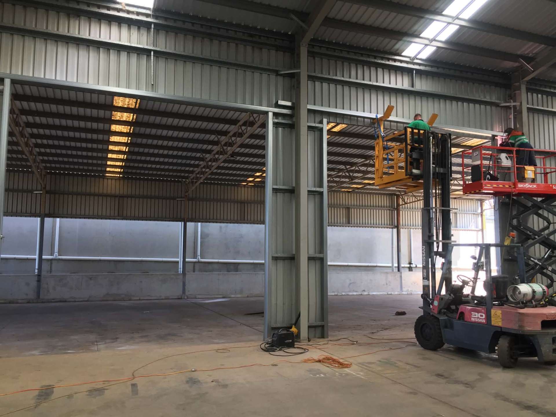 Large commercial roller shutter opened for forklift access during a service call