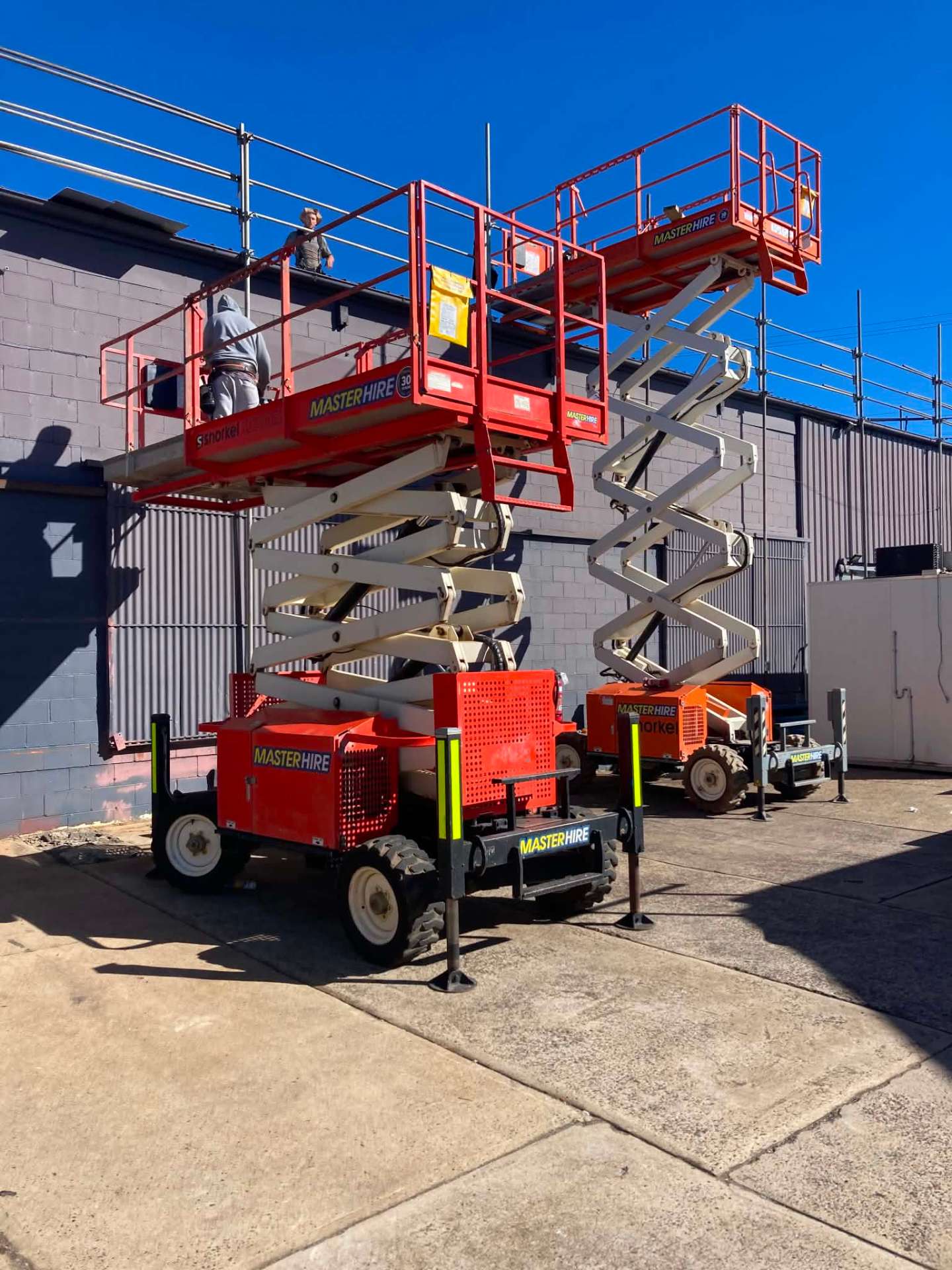 Technicians installing a commercial roller shutter in a new tilt-panel building