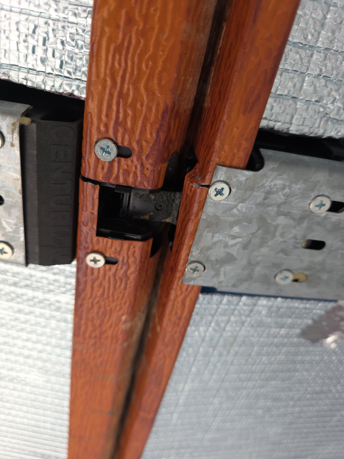 Close-up of Centurion branded plastic hinge showing wear